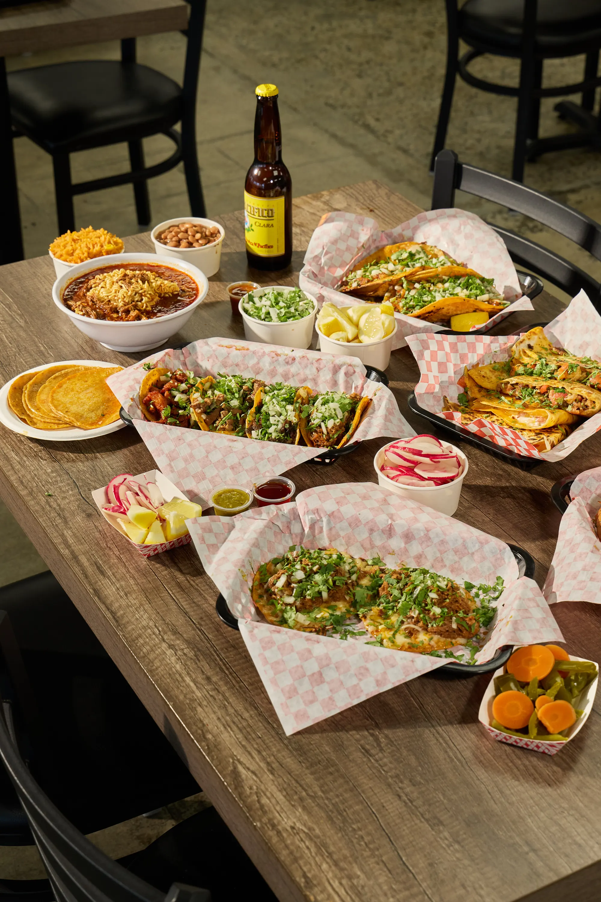 Table spread of birria tacos, quesatacos, birria ramen and quesadillas at Mr. Birria in Santee